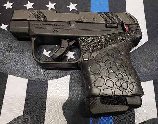 Sent to us from M.F. ..."Installed Tuff 1 Grip Cover on a Ruger LCP 2 (.22).A real must have! Hand gun feels sooo much better in your hand. Gun feels like it is stuck to your hand. I actually installed it over a stick on grip cover that I wasn't thrilled with. All I did was slip on TUFF1 cover over grip as far up as I could, then trimmed around mag eject button and trimmed off the bottom. Simple. Don't hesitate to order!!!"